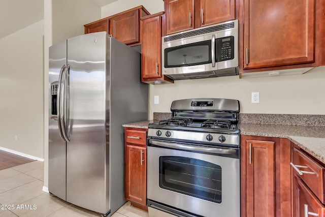 121 W Hackberry Dr, Chandler, AZ 85248 - kitchen featuring appliances with stainless steel finishes, light tile patterned floors, light stone countertops, and brown cabinetry