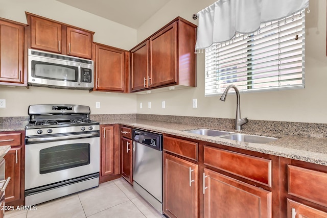 121 W Hackberry Dr, Chandler, AZ 85248 - kitchen featuring appliances with stainless steel finishes, a sink, light tile patterned flooring, brown cabinetry, and light stone counters