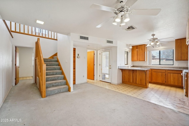 kitchen featuring visible vents, brown cabinets, and light countertops