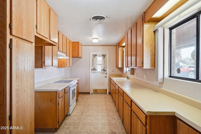 kitchen featuring white electric range oven, light countertops, visible vents, a sink, and under cabinet range hood