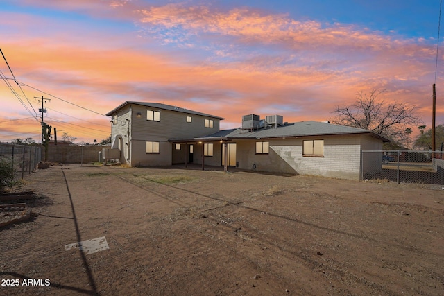 rear view of property featuring cooling unit, a fenced backyard, a patio, and brick siding