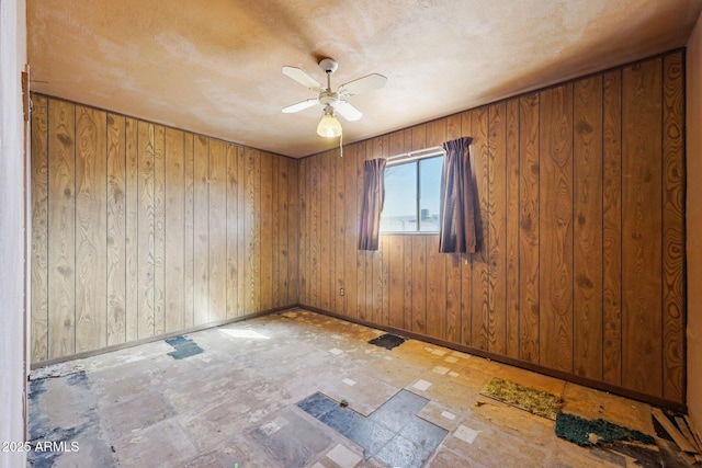 unfurnished room with baseboards and a ceiling fan