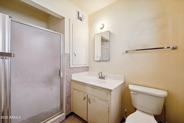 bathroom featuring visible vents, toilet, a shower stall, and vanity