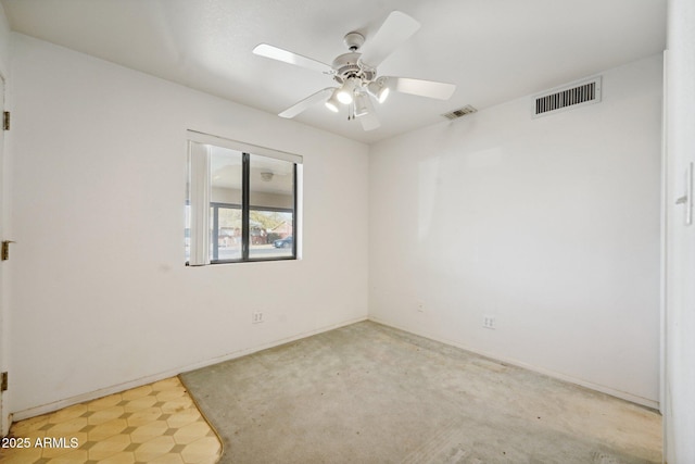 empty room with ceiling fan, light floors, and visible vents