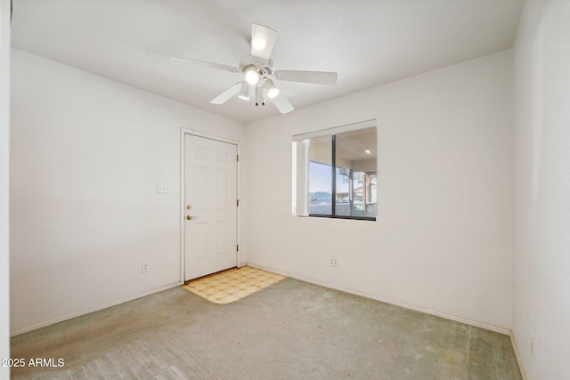 spare room featuring carpet flooring, ceiling fan, and baseboards