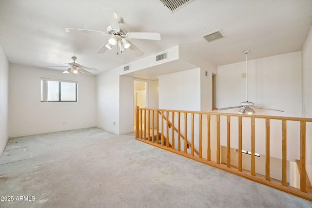 carpeted spare room with ceiling fan and visible vents