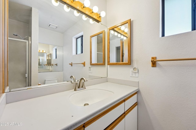 full bathroom featuring an enclosed shower, visible vents, and vanity