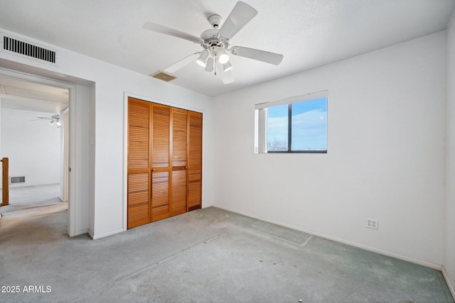 unfurnished bedroom featuring carpet, visible vents, and a closet