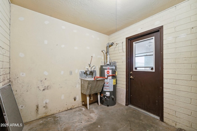 interior space featuring water heater, a sink, and a textured ceiling