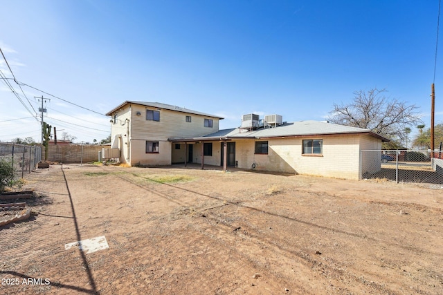 rear view of house with a patio area, central AC, brick siding, and a fenced backyard