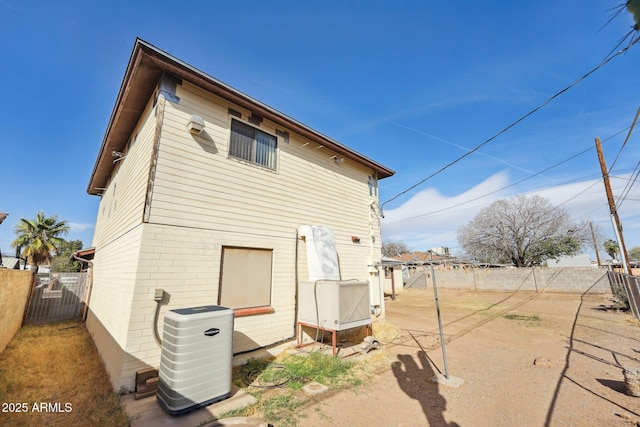 back of house featuring a fenced backyard and cooling unit