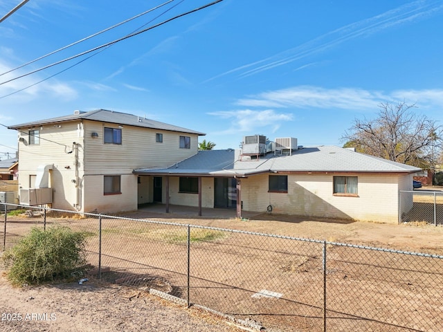 rear view of property with central AC, brick siding, a patio, and a fenced backyard