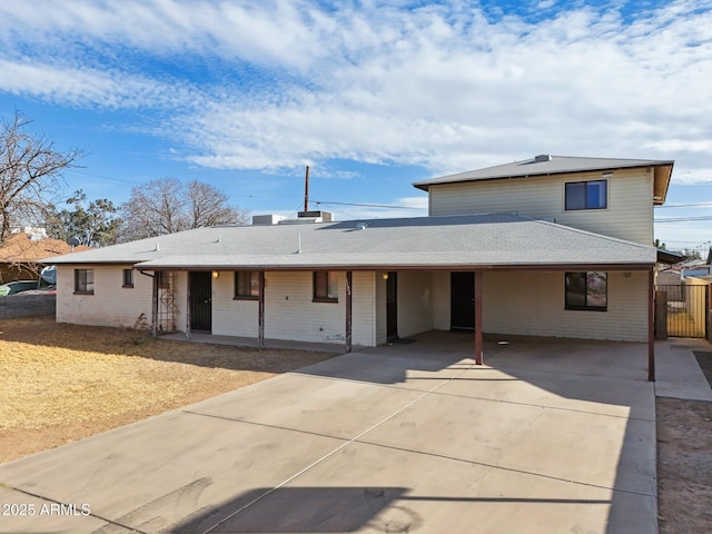 view of front of home with an attached carport, concrete driveway, and brick siding