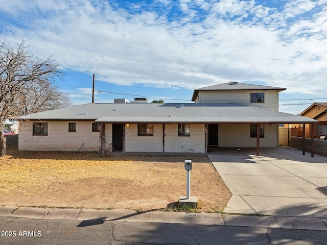 view of front of house featuring a carport, concrete driveway, and brick siding