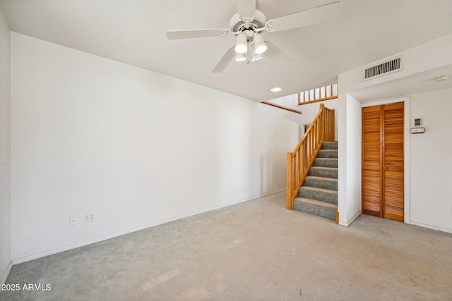 interior space featuring baseboards, visible vents, a ceiling fan, carpet, and stairs