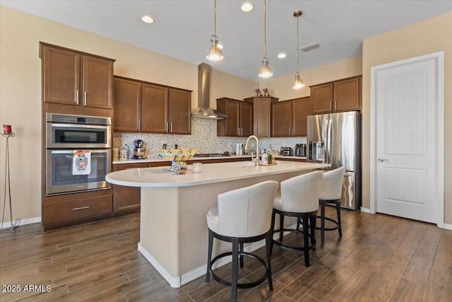 10914 E Tarragon Ave, Mesa, AZ 85212 - kitchen featuring extractor fan, appliances with stainless steel finishes, light countertops, an island with sink, and dark wood finished floors