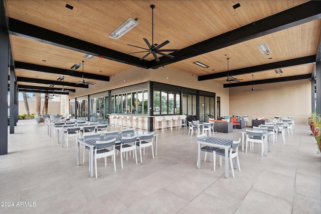 dining area featuring ceiling fan, beam ceiling, and wood ceiling