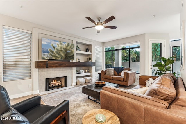 living room with built in shelves and ceiling fan