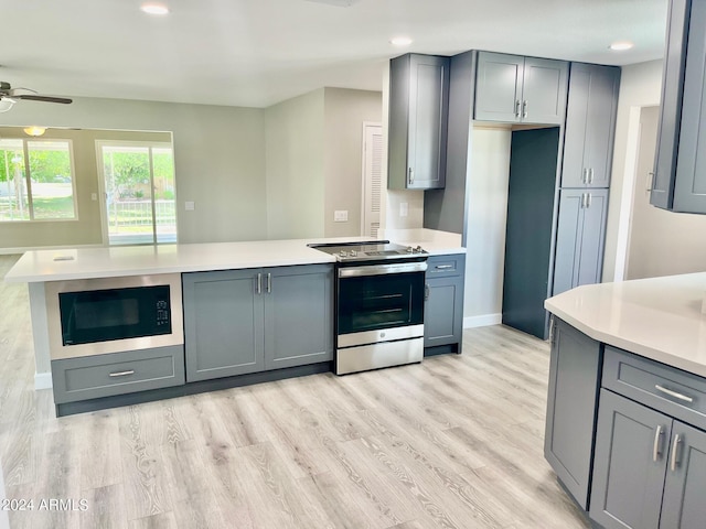 kitchen featuring light countertops, stainless steel electric range, built in microwave, and gray cabinetry