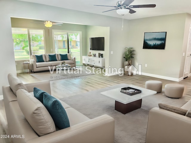 living area featuring wood finished floors, a ceiling fan, and baseboards