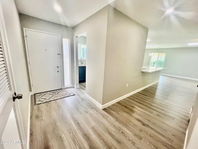 entryway with light wood finished floors and baseboards