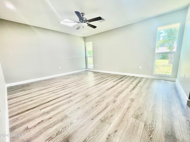 unfurnished room featuring visible vents, baseboards, a ceiling fan, and wood finished floors