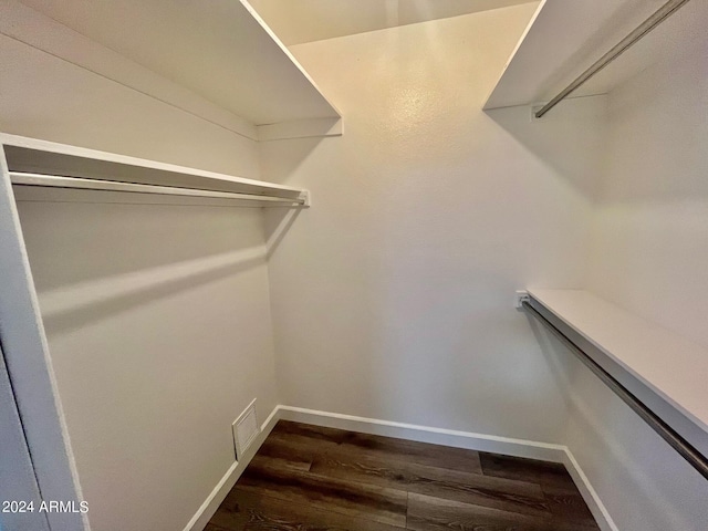 spacious closet featuring dark wood-style floors and visible vents