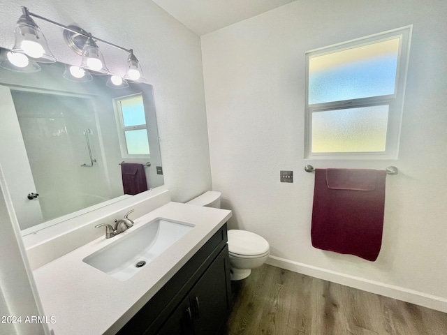 full bath featuring toilet, wood finished floors, baseboards, and plenty of natural light
