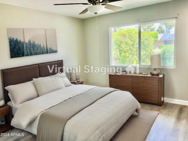 bedroom with light wood-style flooring, baseboards, and ceiling fan