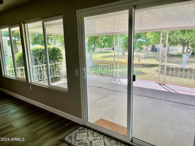 doorway to outside with dark wood-style floors, plenty of natural light, and baseboards