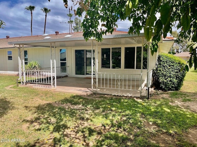 back of house with a lawn and a patio area