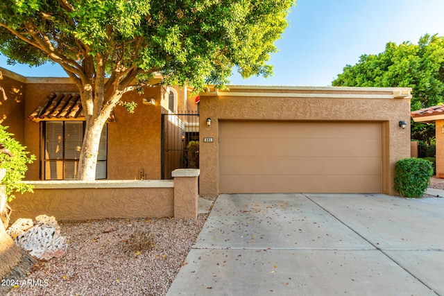 pueblo revival-style home with a garage