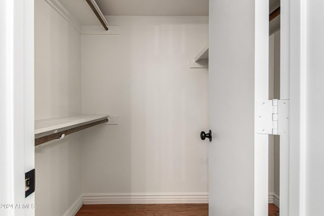 walk in closet with dark wood-type flooring