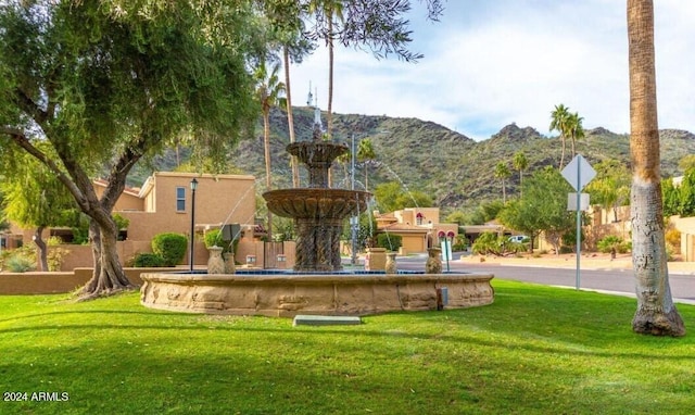 view of community with a mountain view and a lawn