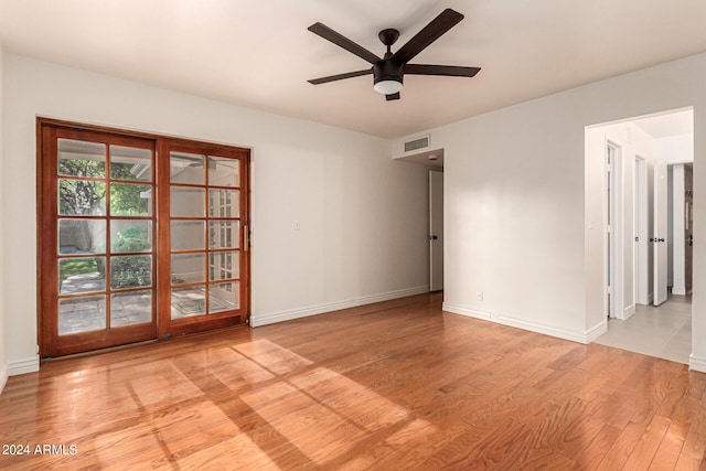 spare room with ceiling fan and light wood-type flooring