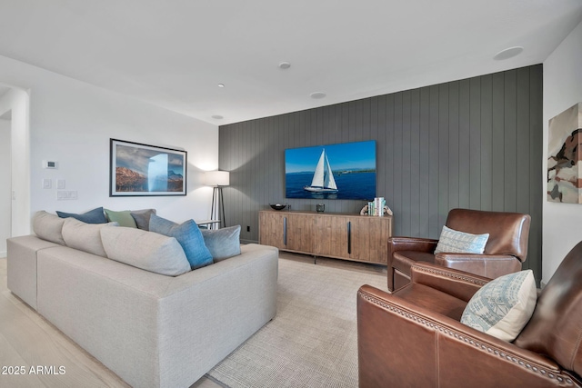 living room featuring light hardwood / wood-style floors and wood walls