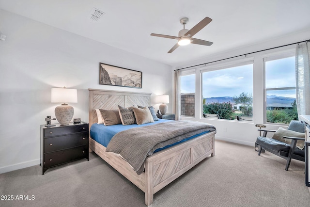 carpeted bedroom with a mountain view and ceiling fan