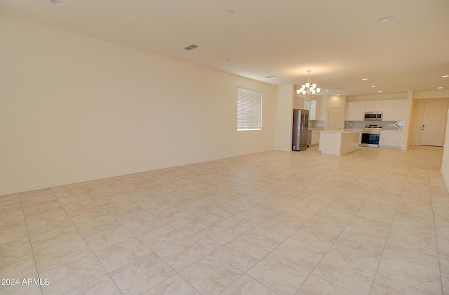 unfurnished living room featuring a chandelier