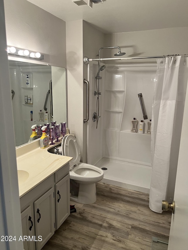 bathroom featuring vanity, toilet, hardwood / wood-style floors, and a shower with curtain