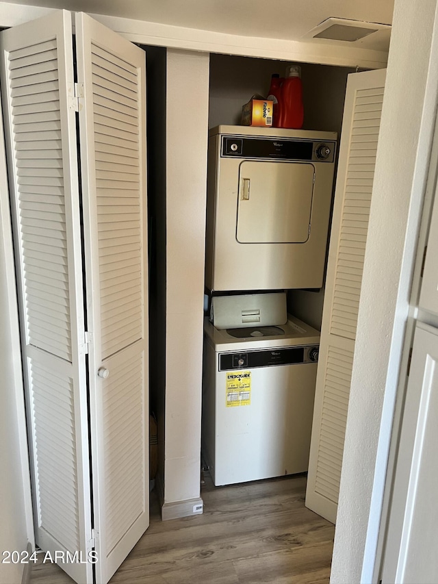 clothes washing area with stacked washer and dryer and light hardwood / wood-style flooring