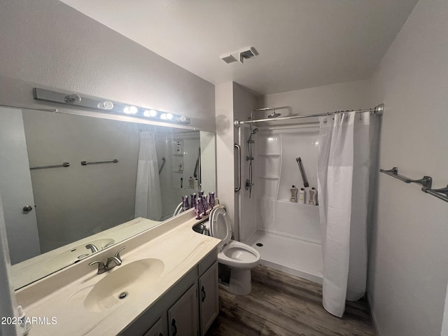 bathroom with a shower with curtain, vanity, hardwood / wood-style flooring, and toilet