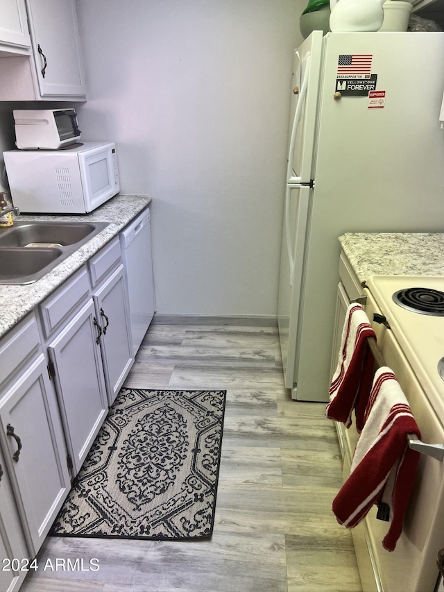 kitchen featuring white cabinetry, white appliances, sink, and light hardwood / wood-style flooring