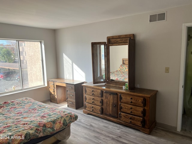 bedroom with multiple windows and light hardwood / wood-style flooring