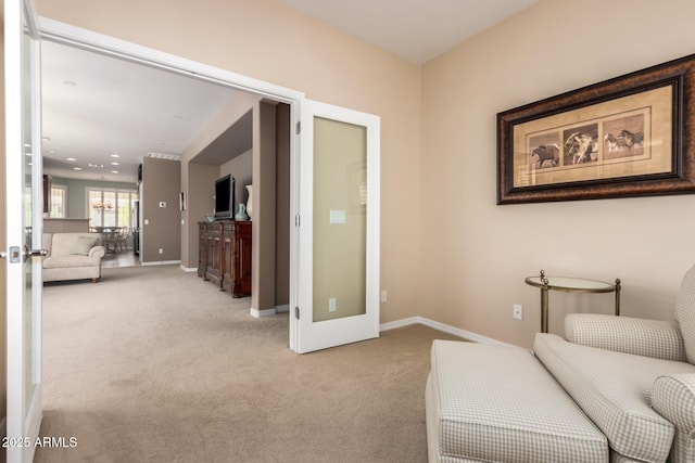 living area featuring light carpet, baseboards, and french doors