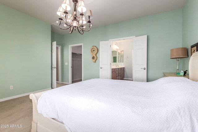 carpeted bedroom featuring baseboards, a spacious closet, a closet, ensuite bath, and an inviting chandelier