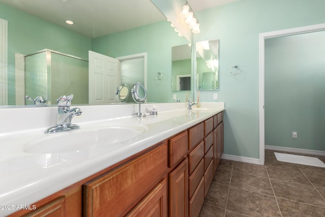 bathroom featuring double vanity, tile patterned flooring, baseboards, and a sink