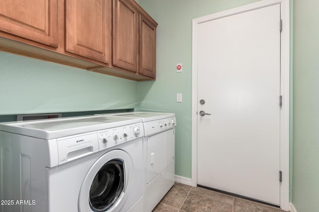 washroom with washing machine and dryer, cabinet space, and baseboards