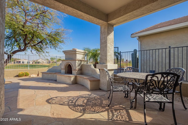 view of patio featuring fence, an outdoor fireplace, and outdoor dining space