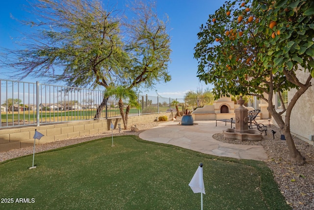 exterior space featuring a patio area, an outdoor fireplace, and fence