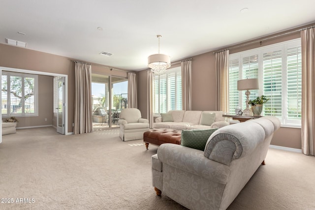 living area with light carpet, a healthy amount of sunlight, and visible vents